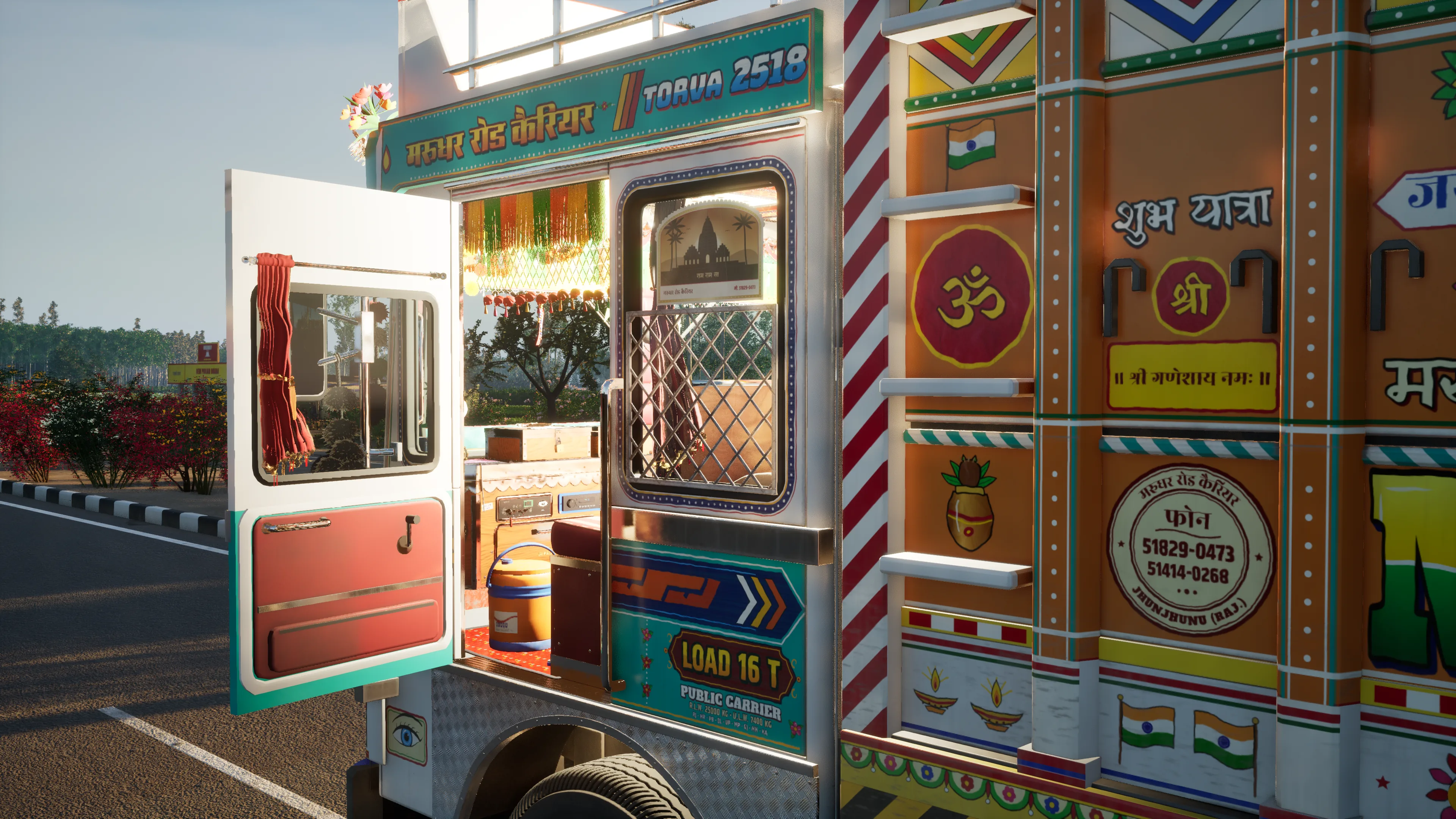 The painted side of the truck with the passenger door open, an Om, Indian flags and the Hindi words Shubh Yatra on the orange body panels
