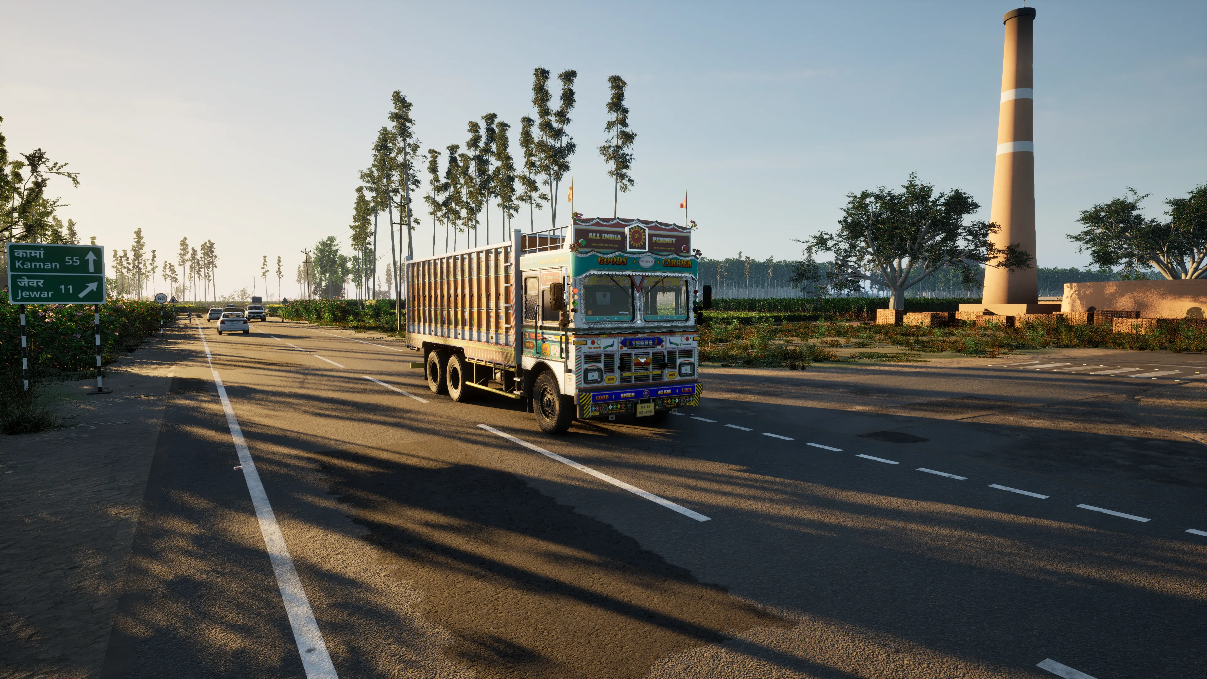 A painted truck on a two-lane country road in low evening sun, tall poplars and fields behind it